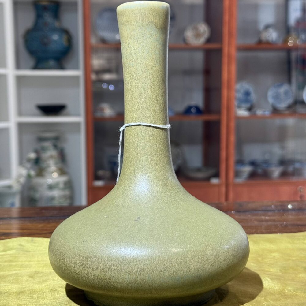 A green glaze vase with long neck